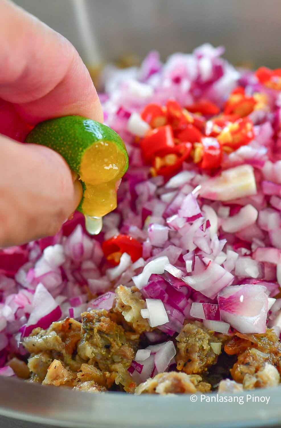 Squeezing calamansi over sisig